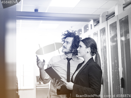 Image of engineer showing working data center server room to female chief