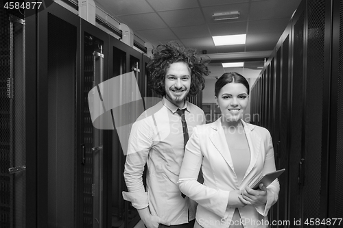 Image of engineer showing working data center server room to female chief