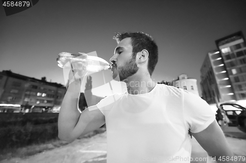 Image of man drinking water after running session