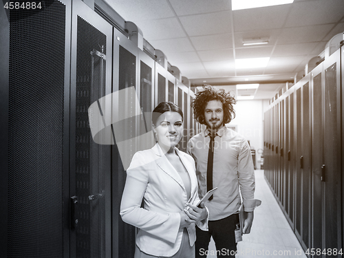 Image of engineer showing working data center server room to female chief