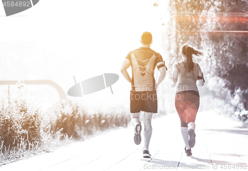 Image of young couple jogging  in the city