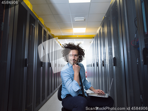 Image of engineer working on a laptop in server room