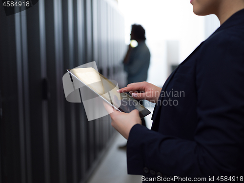 Image of Female engineer working on a tablet computer in server room