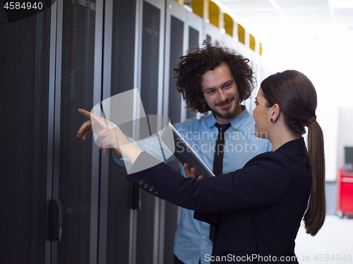 Image of engineer showing working data center server room to female chief