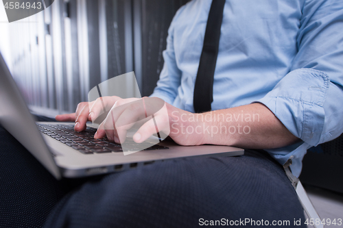 Image of engineer working on a laptop in server room