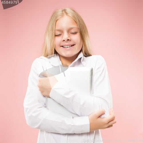 Image of Teen girl with laptop. Love to computer concept. Attractive female half-length front portrait, trendy pink studio backgroud.