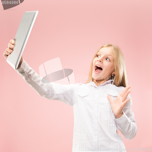 Image of Teen girl with laptop. Love to computer concept. Attractive female half-length front portrait, trendy pink studio backgroud.