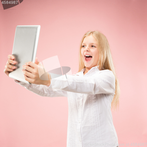 Image of Teen girl with laptop. Love to computer concept. Attractive female half-length front portrait, trendy pink studio backgroud.