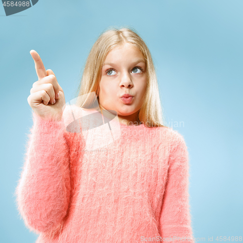 Image of Beautiful teen girl looking suprised isolated on blue