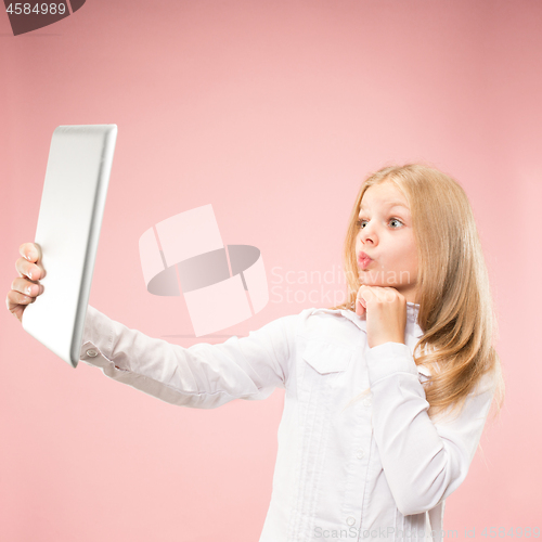 Image of Teen girl with laptop. Love to computer concept. Attractive female half-length front portrait, trendy pink studio backgroud.