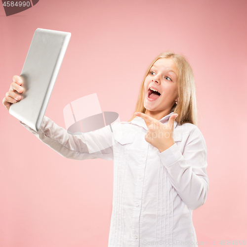 Image of Teen girl with laptop. Love to computer concept. Attractive female half-length front portrait, trendy pink studio backgroud.