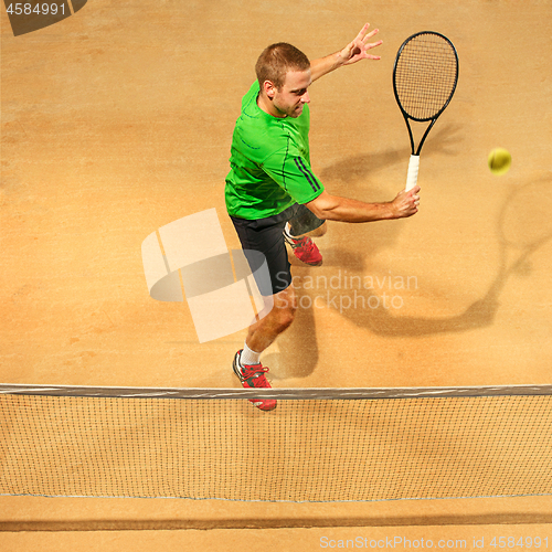 Image of The one jumping player, caucasian fit man, playing tennis on the earthen court