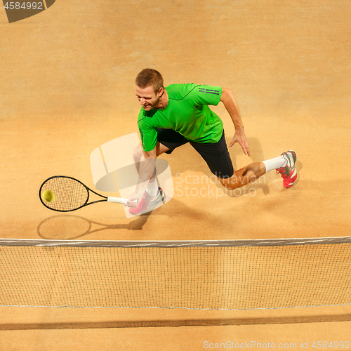 Image of The one jumping player, caucasian fit man, playing tennis on the earthen court