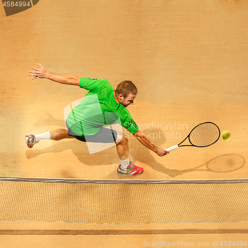 Image of The one jumping player, caucasian fit man, playing tennis on the earthen court