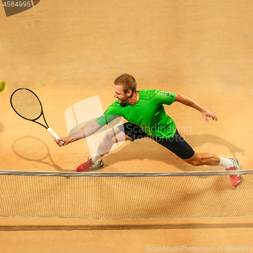 Image of The one jumping player, caucasian fit man, playing tennis on the earthen court