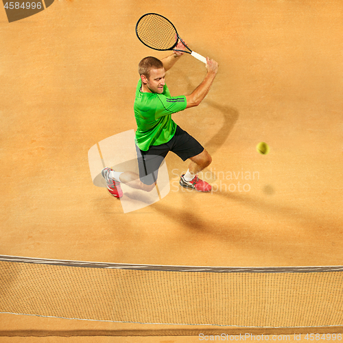 Image of The one jumping player, caucasian fit man, playing tennis on the earthen court