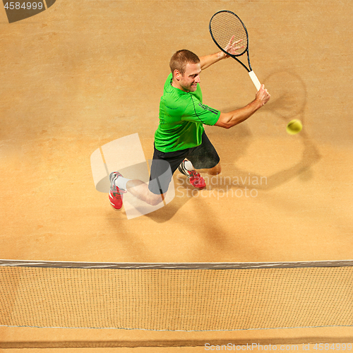 Image of The one jumping player, caucasian fit man, playing tennis on the earthen court