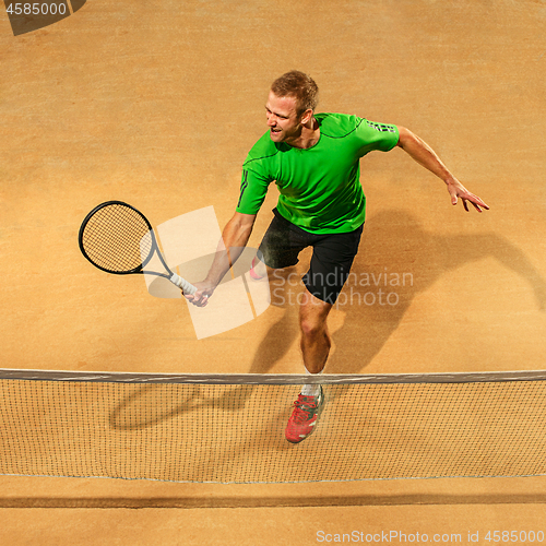 Image of The one jumping player, caucasian fit man, playing tennis on the earthen court