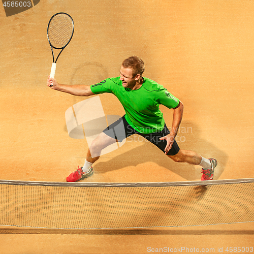 Image of The one jumping player, caucasian fit man, playing tennis on the earthen court