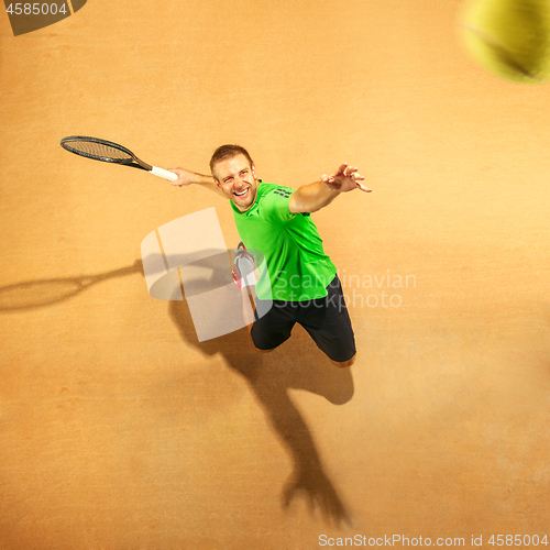 Image of The one jumping player, caucasian fit man, playing tennis on the earthen court