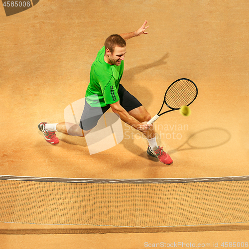 Image of The one jumping player, caucasian fit man, playing tennis on the earthen court