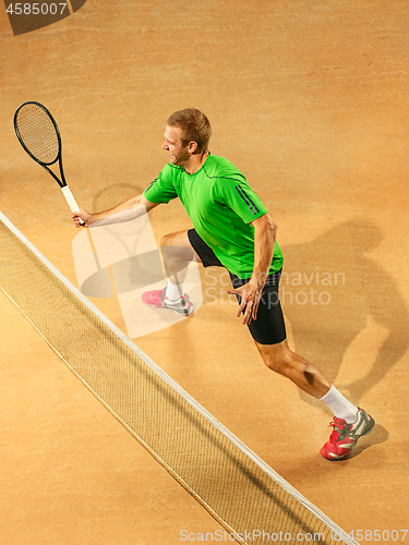 Image of The one jumping player, caucasian fit man, playing tennis on the earthen court