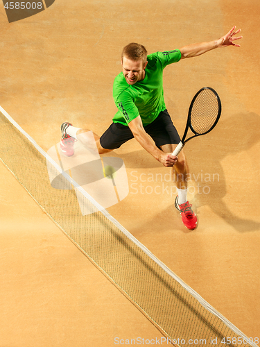 Image of The one jumping player, caucasian fit man, playing tennis on the earthen court