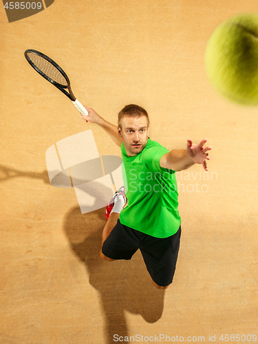 Image of The one jumping player, caucasian fit man, playing tennis on the earthen court