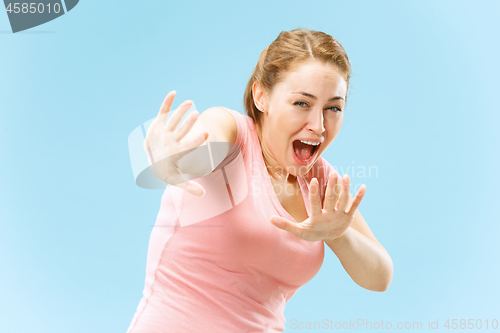 Image of Portrait of the scared woman on blue