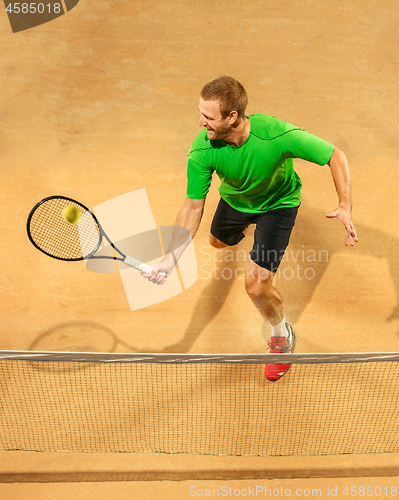 Image of The one jumping player, caucasian fit man, playing tennis on the earthen court