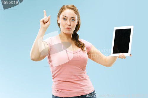 Image of Portrait of a confident casual girl showing blank screen of laptop isolated over blue background