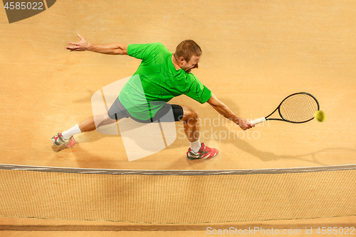 Image of The one jumping player, caucasian fit man, playing tennis on the earthen court