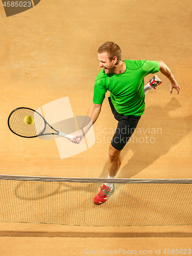 Image of The one jumping player, caucasian fit man, playing tennis on the earthen court