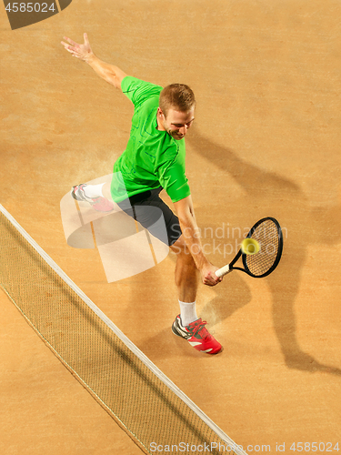 Image of The one jumping player, caucasian fit man, playing tennis on the earthen court