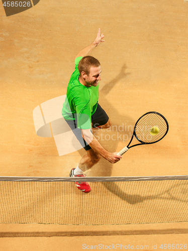 Image of The one jumping player, caucasian fit man, playing tennis on the earthen court