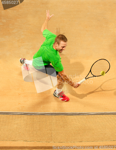 Image of The one jumping player, caucasian fit man, playing tennis on the earthen court