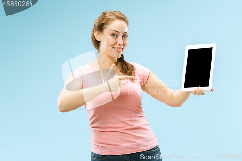 Image of Portrait of a confident casual girl showing blank screen of laptop isolated over blue background