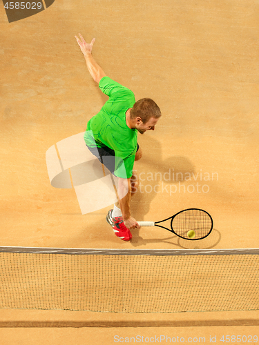 Image of The one jumping player, caucasian fit man, playing tennis on the earthen court