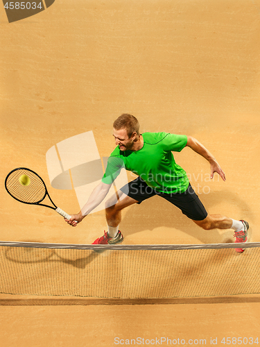 Image of The one jumping player, caucasian fit man, playing tennis on the earthen court