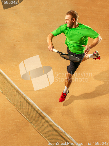 Image of The one jumping player, caucasian fit man, playing tennis on the earthen court