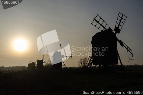 Image of Traditional windmills silhouettes by the setting sun