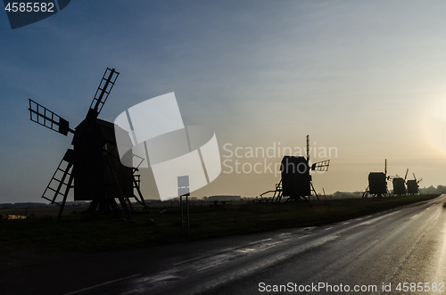 Image of Old wooden windmill silhouettes in a row