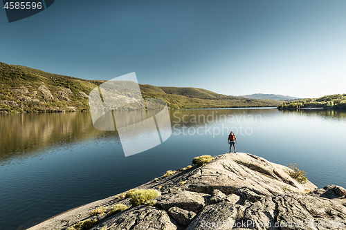 Image of Man hiking near a beautiful lake