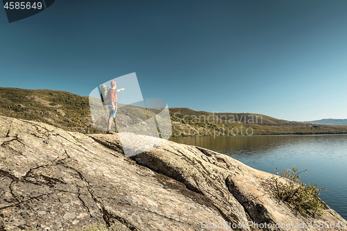 Image of Man hiking near a beautiful lake