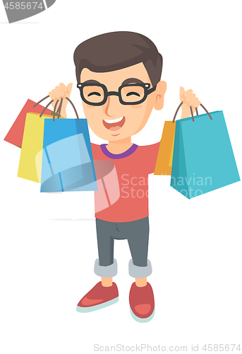 Image of Happy caucasian boy holding shopping bags.