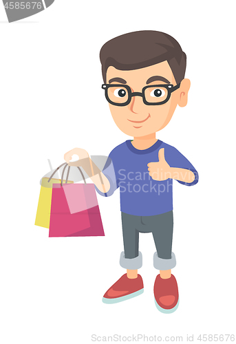 Image of Happy caucasian boy holding shopping bags.