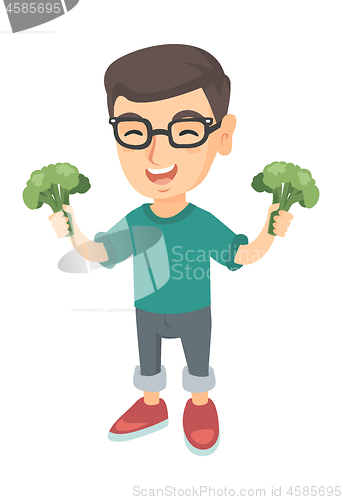 Image of Little caucasian boy laughing and holding broccoli