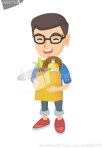 Image of Boy holding paper shopping bag full of groceries.