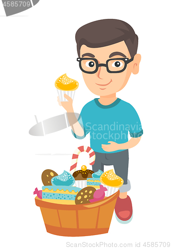 Image of Boy holding a cupcake and stroking his belly.