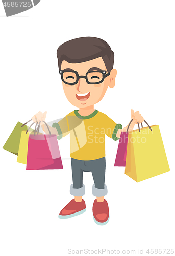 Image of Happy caucasian boy holding shopping bags.